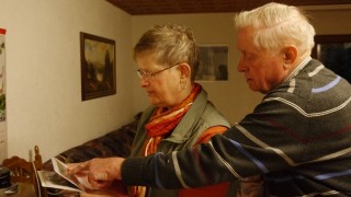 Johann Grommes und seine Tochter Erika beim Betrachten von Bildern aus Jakobsdorf