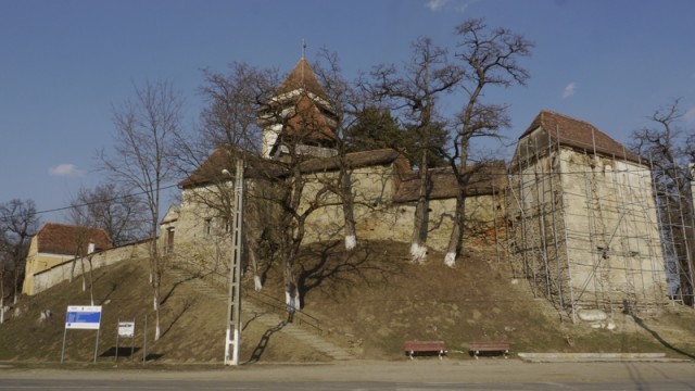 Die Kirchenburg Trappold von der Hauptstraße aus gesehen. Das Baustellenschild links unten beweist es: Die Europäische Union hat es auch nach Trappold geschafft. Sie unterstützt die Instandsetzung des Baudenkmals.