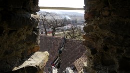 Blick durch eine Schießscharte auf das Dach des alten Speckhauses, das gerade repariert wird (Foto: Nancy Waldmann)