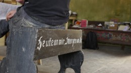 Bethge sitzt in seinem Büro auf einer alten Totenbank aus der Kirche. (Foto: Nancy Waldmann)